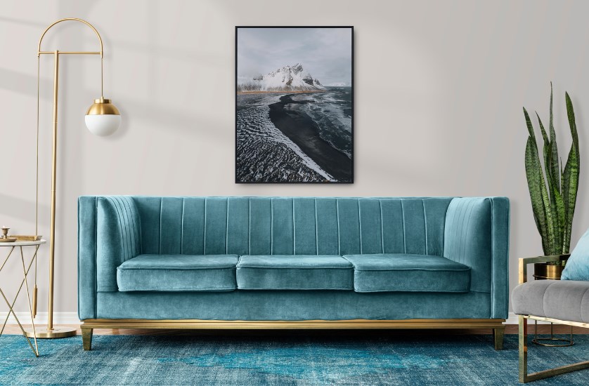 A velvet Art Deco sofa with gold accents in a living room setting